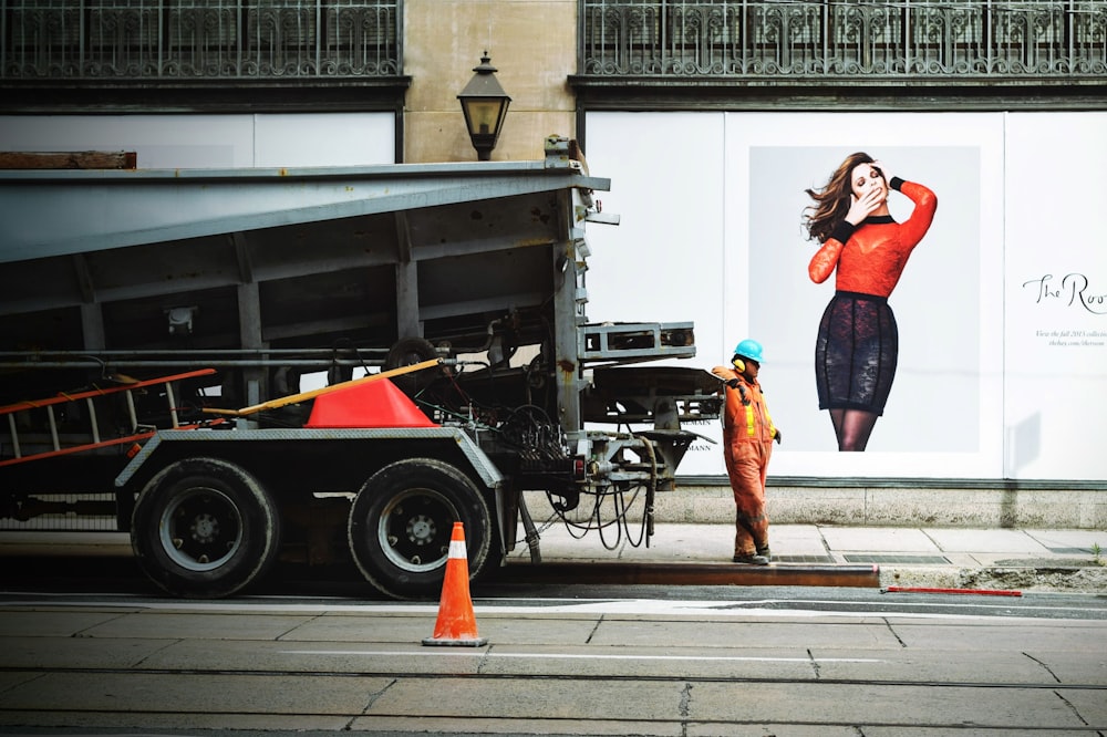 person wearing orange suit while leaning on truck