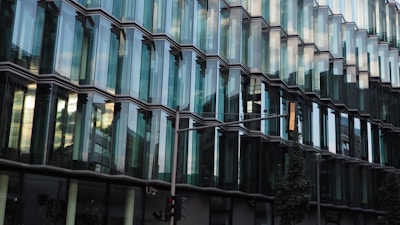 A commercial complex with glass facade and busy street view.