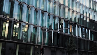 A commercial complex with glass facade and busy street view.