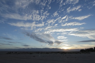 A warm, inviting photo of a happy family enjoying a scenic Saudi Arabian desert sunset.