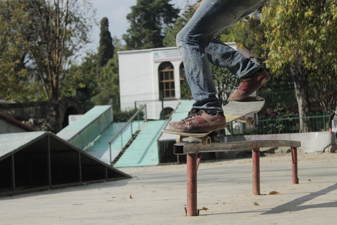 person skating on rail during daytime