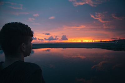 person standing near sea under cloudy sky contemplative teams background