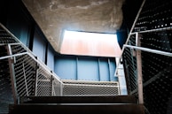 A wide metal staircase with custom steps leading to a bright loft space.