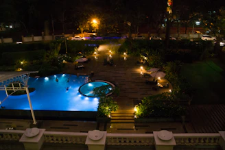 A nighttime view of a pool with underwater LED lighting glowing.
