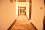 A hallway with doors leading to various guest rooms, well-lit and clean.