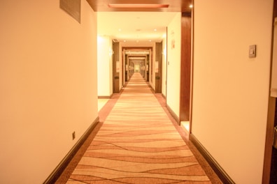 A hallway with doors leading to various guest rooms, well-lit and clean.