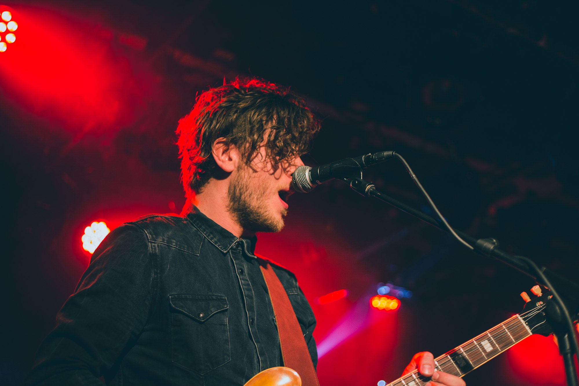 Band member under red floodlights