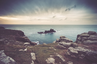 The rugged coastline of Galicia under a dramatic cloudy sky at sunset.
