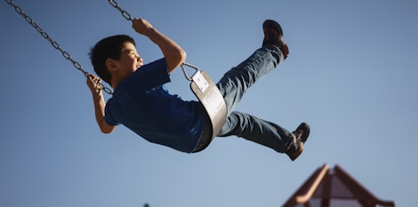 boy sitting on swing chair