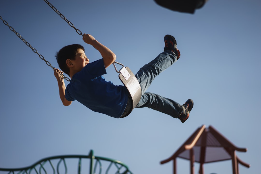 boy sitting on swing chair