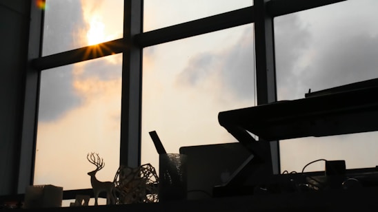 A serene workspace with a person meditating near a window, sunlight casting soft shadows.