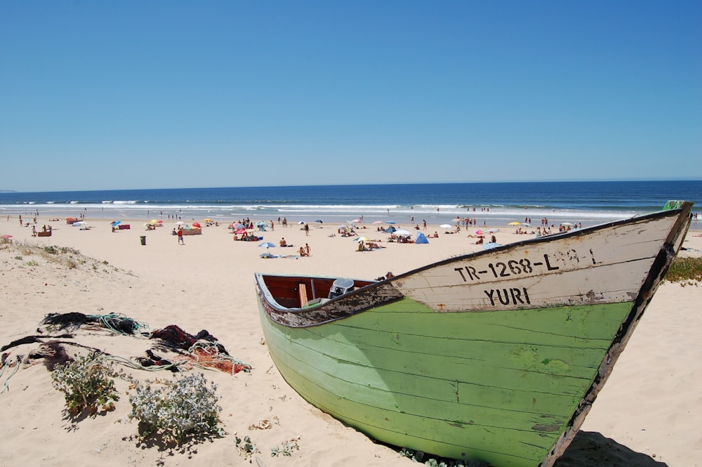 Barco verde a la orilla del mar