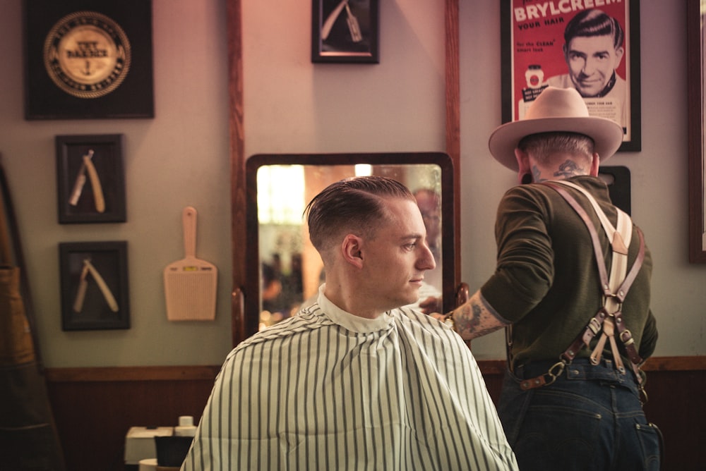 man sitting on chair inside barber shop