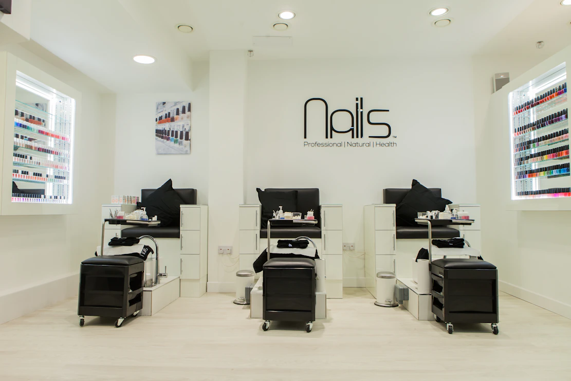 A sleek, minimal login panel with soft pink and white tones reflecting a cozy nail salon atmosphere.