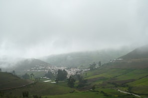 Fog rolling over a rural French village under a gloomy sky at dusk