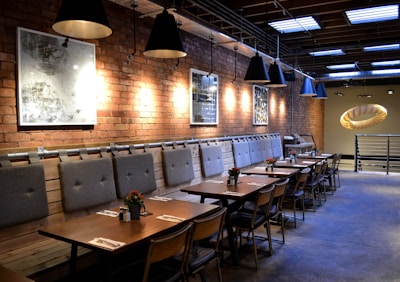 Open-plan dining area with rustic table and modern lighting fixtures.