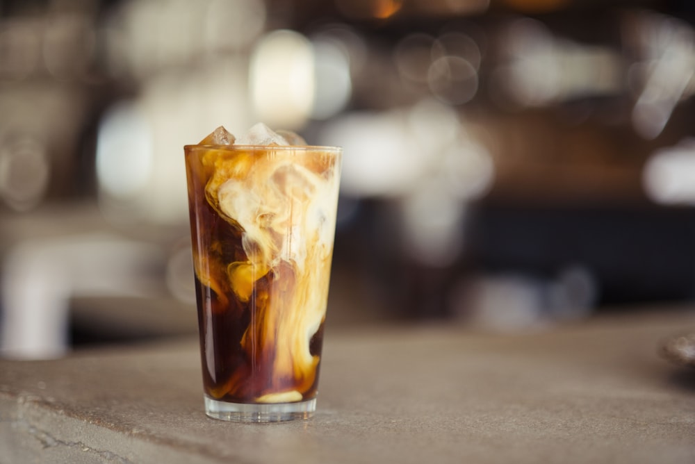 tasse en verre remplie de glace latte sur la table