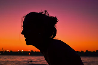 A silhouette of a woman at sunset, highlighting sensual curves and grace.