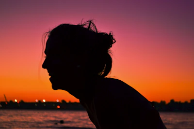 A silhouette of a woman at sunset, highlighting sensual curves and grace.