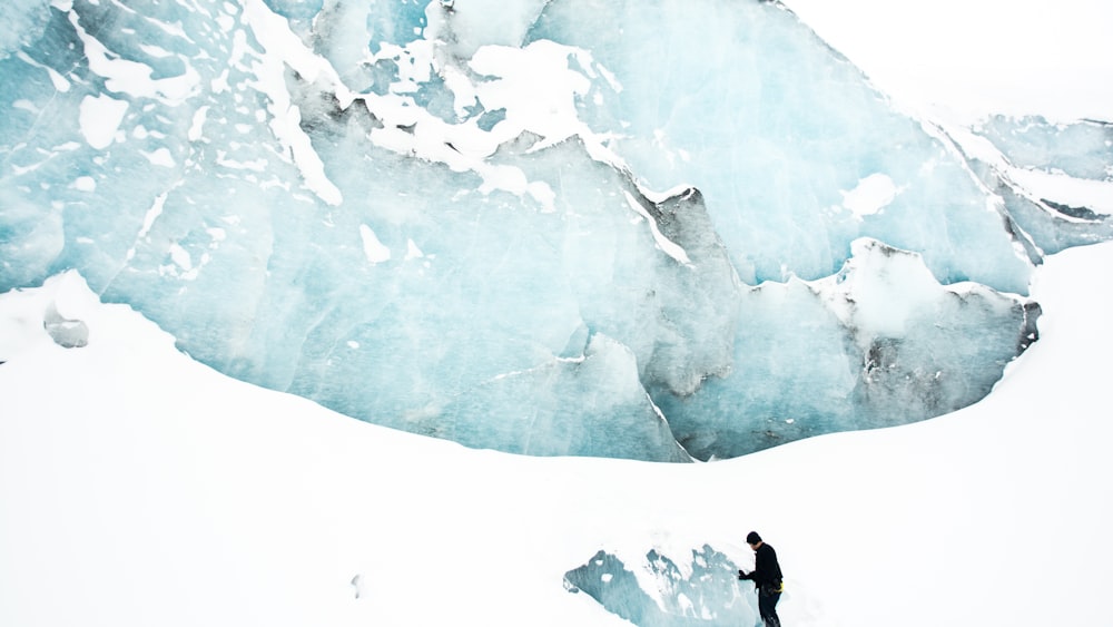 person standing on snow field near mountain