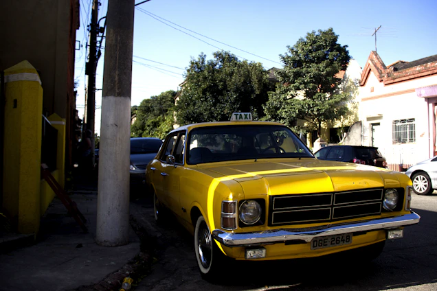 A bright yellow taxi parked on a city street in Erode with a driver ready to assist a passenger.