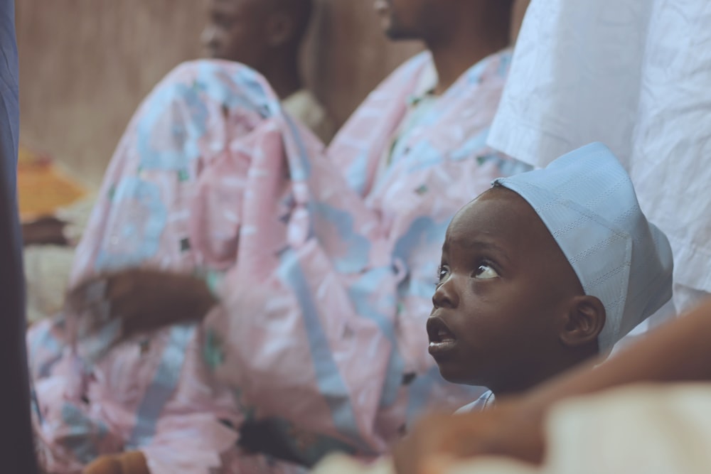 shallow focus photography of boy with white hat