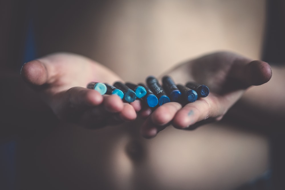 person holding blue crayons