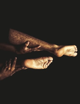a couple of people with bare feet on a black background