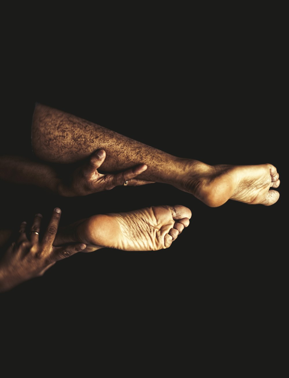 a couple of people with bare feet on a black background