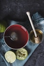 red ceramic bowl filled with water beside lime and honey