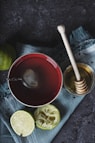 red ceramic bowl filled with water beside lime and honey