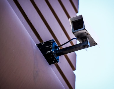 gray surveillance camera on gray wall