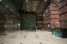 A friendly medical professional warmly greeting a hotel guest in a luxurious lobby.