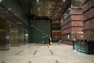 Elegant real estate agent welcoming clients in a modern luxury home lobby.