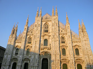 A colorful virtual tour scene of La Sagrada Familia basilica bathed in warm sunlight.