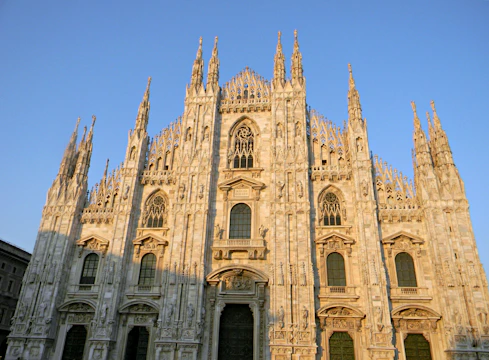 A colorful virtual tour scene of La Sagrada Familia basilica bathed in warm sunlight.