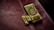 A close-up of a polished gold combination lock attached to a distressed, dark red leather surface, likely part of a briefcase or similar item.