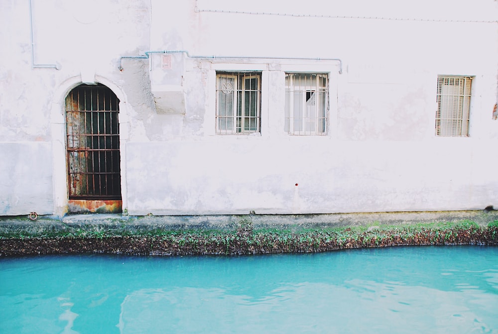 body of water beside white concrete house]