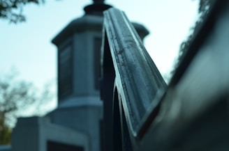 Close-up of a sleek, metallic architectural structure with sharp angles and reflective surfaces under cool lighting.