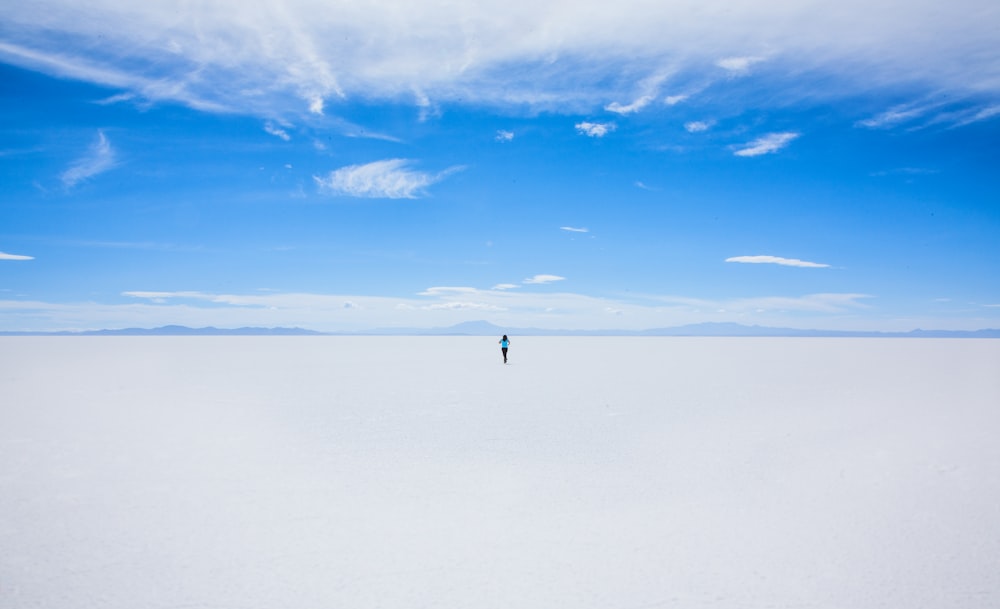 person walking of sand covered field during daytime