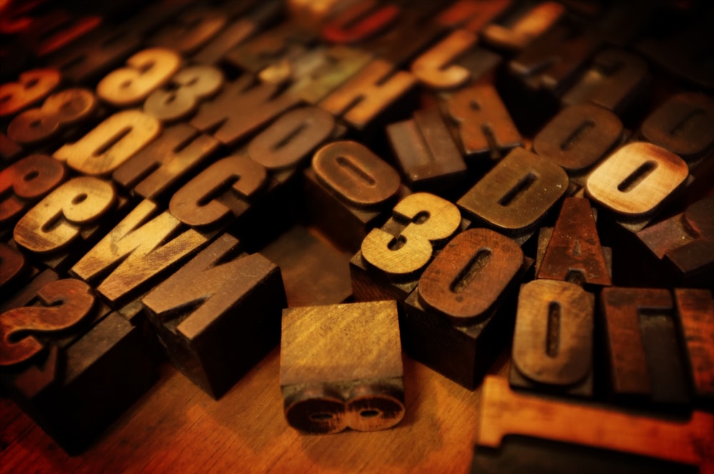 tilt shift lens photography close shot of brown letter and number blocks