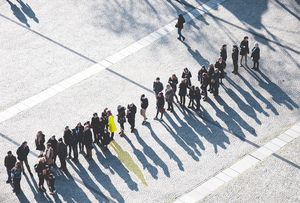 A woman in a yellow jacket standing amongst a group of people in black jacket