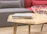 Close-up of a sleek industrial coffee table with a textured metal frame and wooden top.