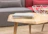 Close-up of a sleek industrial coffee table with a textured metal frame and wooden top.