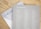 Two books are placed on a light wooden surface. The top book is titled 'The Unsplash Book' and features a list of names printed in white on a light gray cover. Part of the title 'THE KIN' is visible on the book underneath, with a partially visible white cover and black text.