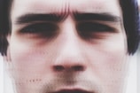 A close-up of a human face with furrowed brows, showing signs of concentration or concern. The image is slightly blurred around the edges, adding a sense of softness.