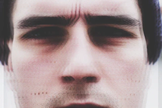 A close-up of a person with a furrowed brow, lost in a swirl of floating, overlapping thought bubbles.