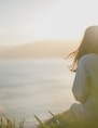 woman wearing gray long-sleeved shirt facing the sea