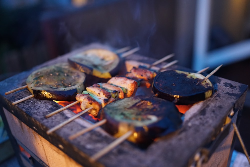 three assorted barbeques on black grill