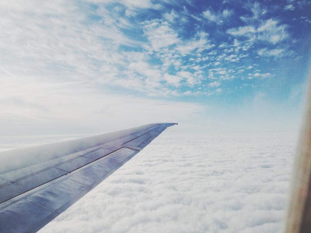 白い雲の上に舞い上がる飛行機の翼